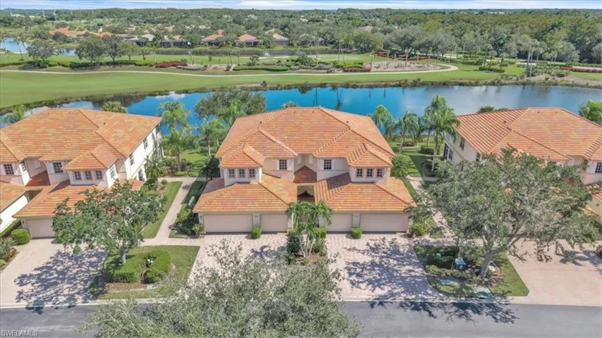 Aerial perspective of suburban area with a large body of water and a golf course