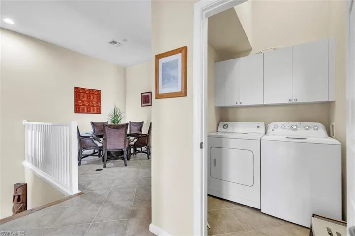 Laundry room featuring cabinet space, washer and dryer, and light tile patterned floors