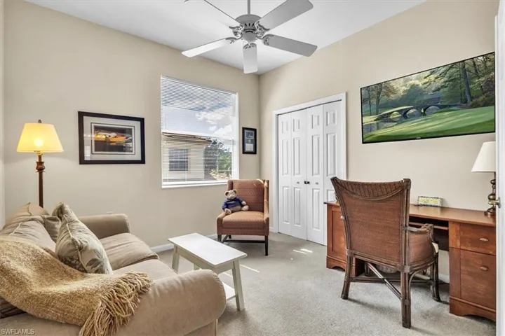 Carpeted office with ceiling fan and baseboards
