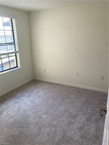 Empty room with carpet floors and baseboards