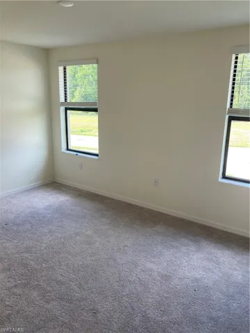 Unfurnished room with carpet and baseboards