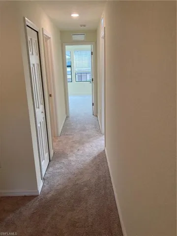 Hall with light carpet and baseboards