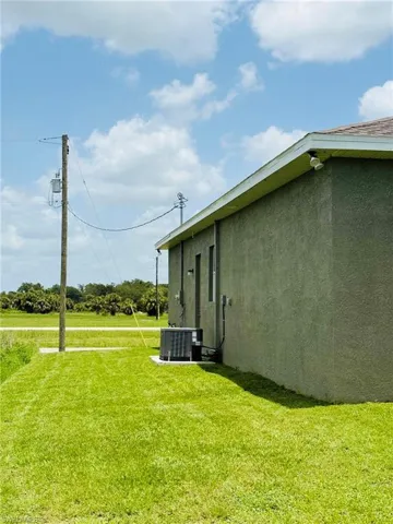 View of green lawn with central AC unit