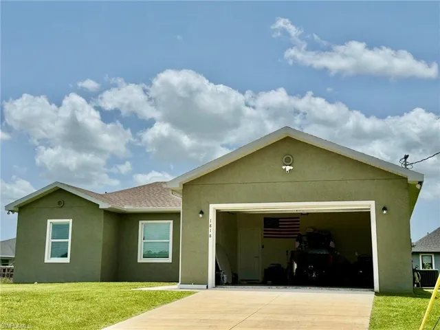 View of front facade featuring concrete driveway, a garage, stucco siding, a front yard, and a shingled roof