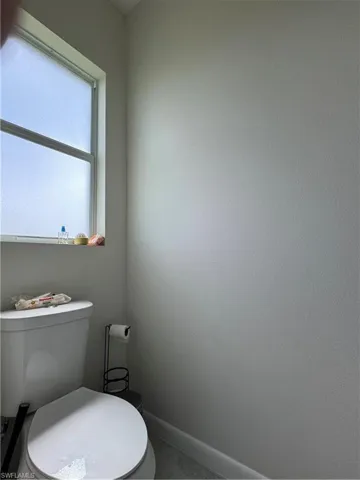 Bathroom with toilet and baseboards