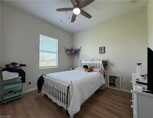 Bedroom featuring wood finished floors, baseboards, and a ceiling fan