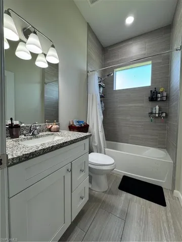 Bathroom with shower / tub combo, vanity, and toilet