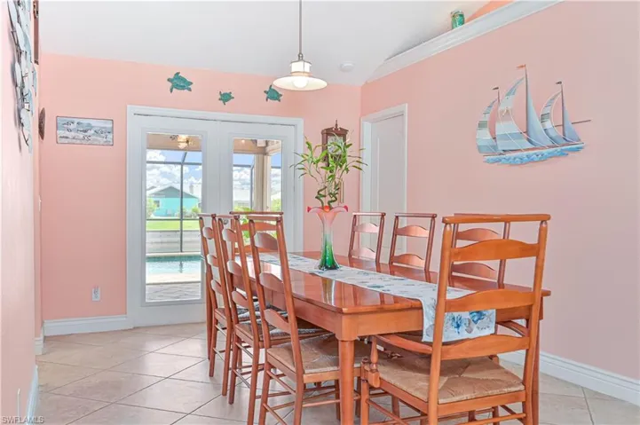 Dining room featuring french doors, light tile patterned flooring, and baseboards