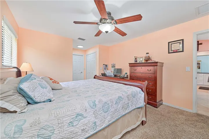Bedroom featuring light carpet, baseboards, and ceiling fan