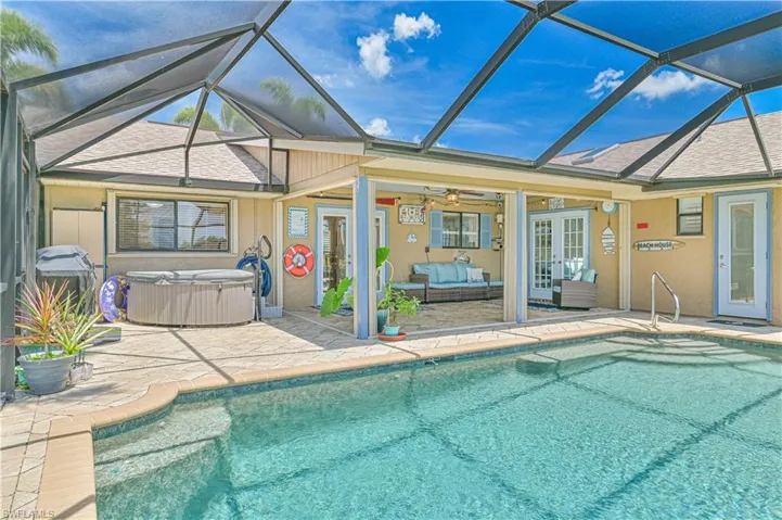 Swimming pool featuring a hot tub, a patio area, outdoor lounge area, french doors, and a lanai