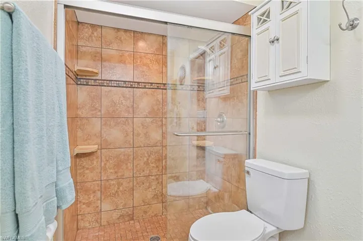 Bathroom featuring toilet and a stall shower
