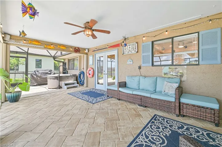 View of patio featuring french doors, a hot tub, ceiling fan, and an outdoor hangout area