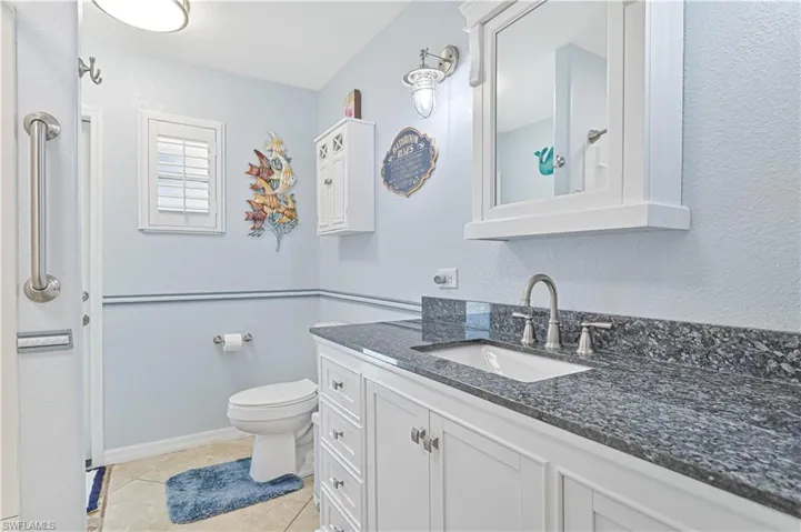 Bathroom with vanity, toilet, and tile patterned floors