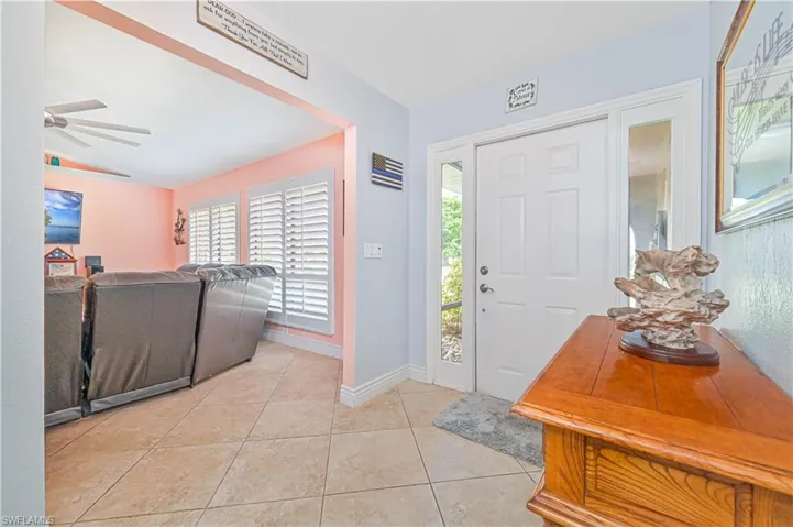 Entrance foyer featuring plenty of natural light, light tile patterned flooring, a ceiling fan, vaulted ceiling, and baseboards