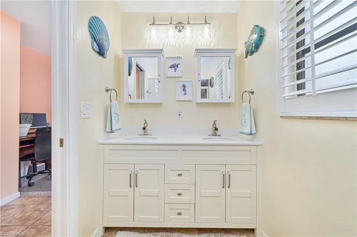 Full bath featuring double vanity and tile patterned floors