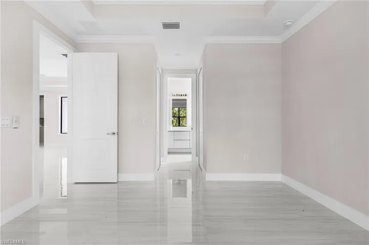 Unfurnished room featuring crown molding and baseboards