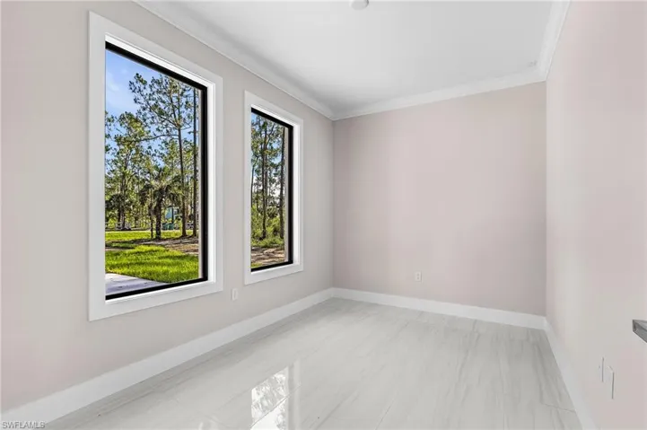 Spare room featuring ornamental molding and baseboards