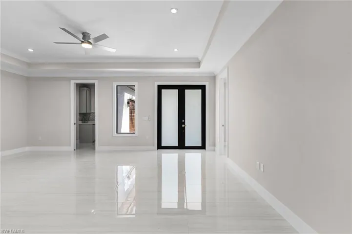 Unfurnished bedroom with french doors, a raised ceiling, ornamental molding, a ceiling fan, and recessed lighting