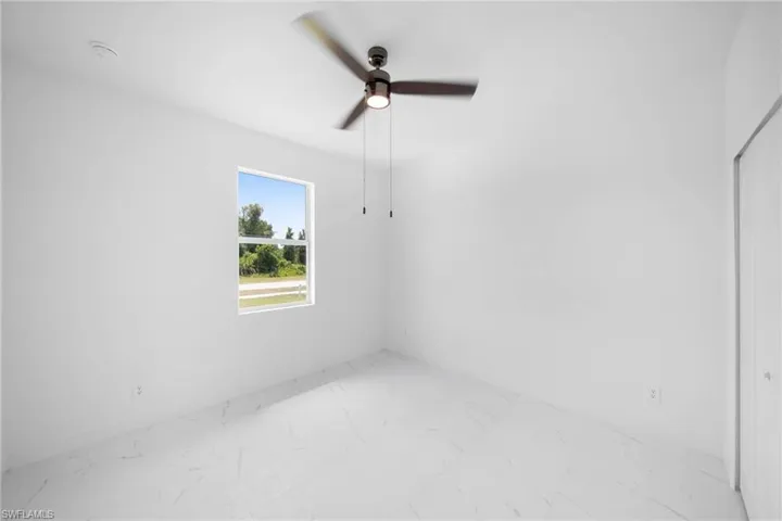 Unfurnished room featuring tile floors and ceiling fan