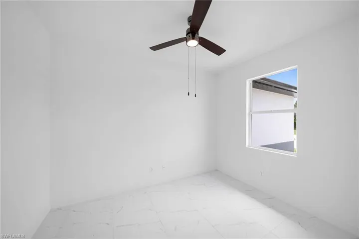 Unfurnished room featuring ceiling fan and light tile flooring