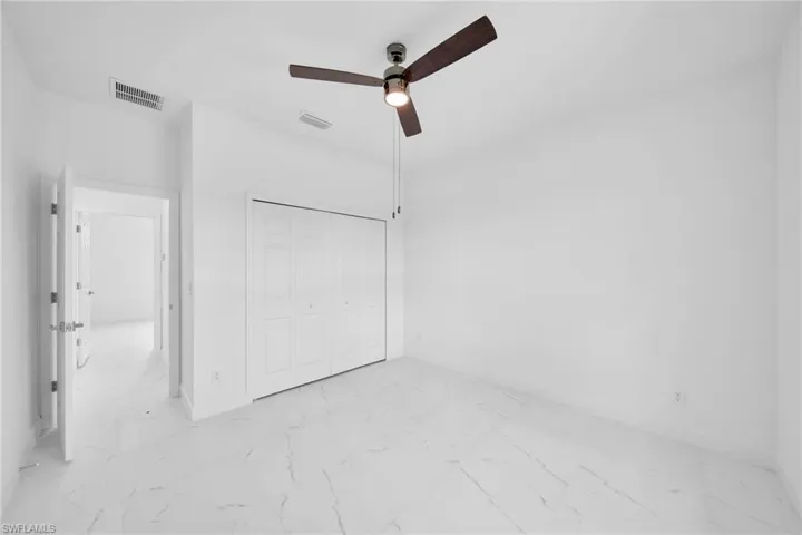 Unfurnished bedroom with a closet, ceiling fan, and light tile floors