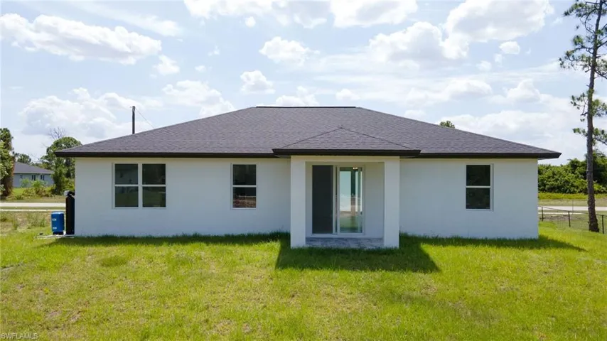 Back of house with a lawn