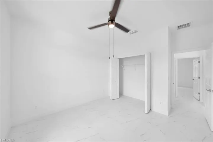 Unfurnished bedroom with a closet, ceiling fan, and light tile floors