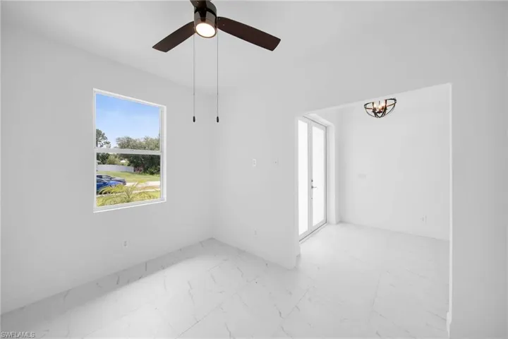 Tiled spare room featuring ceiling fan