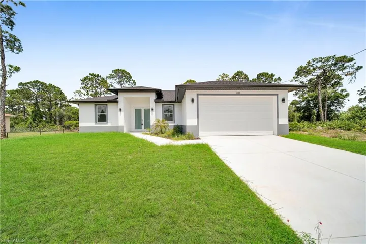 View of front of house with a garage and a front yard