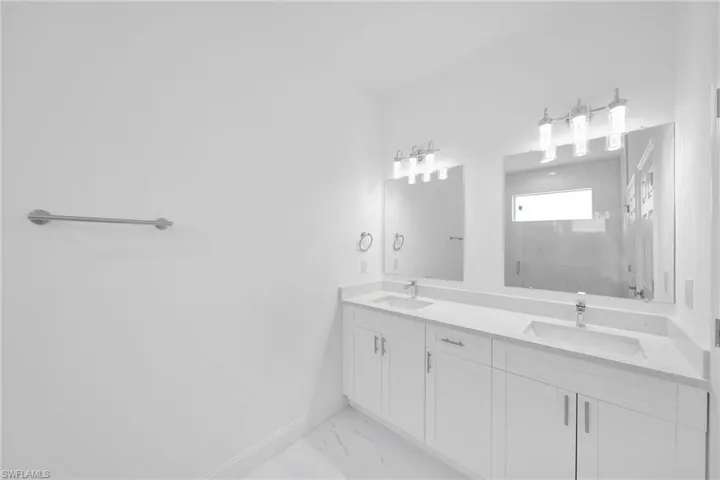 Bathroom with dual bowl vanity and tile floors