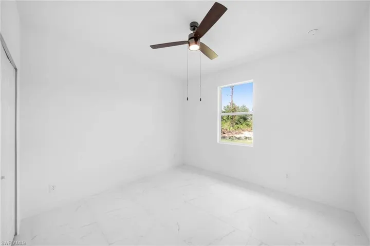 Tiled empty room featuring ceiling fan