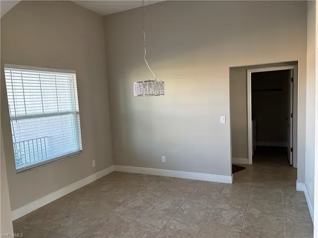 Unfurnished room featuring a towering ceiling
