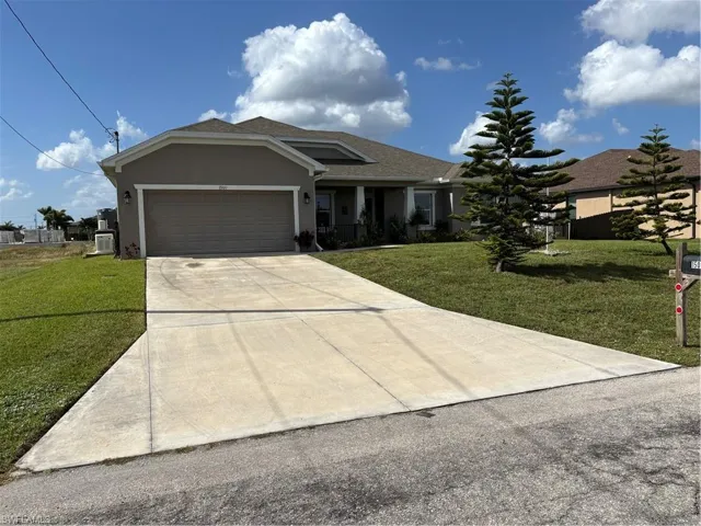 View of front facade featuring a garage and a front yard