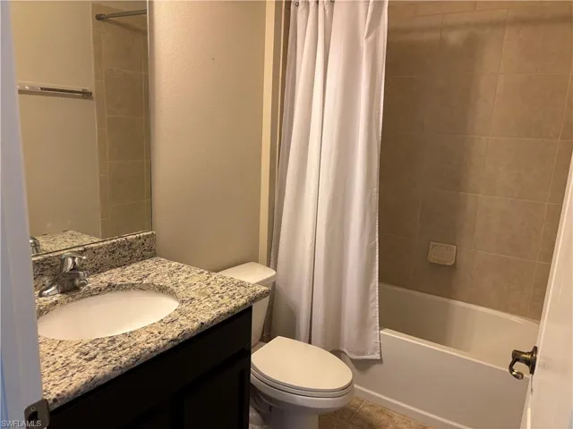 Full bathroom with tile shower / tub, toilet, and vanity