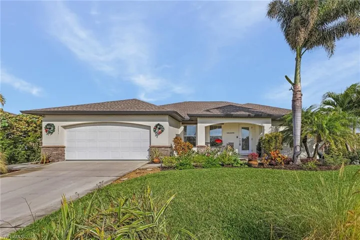View of front of home with a front yard and a garage