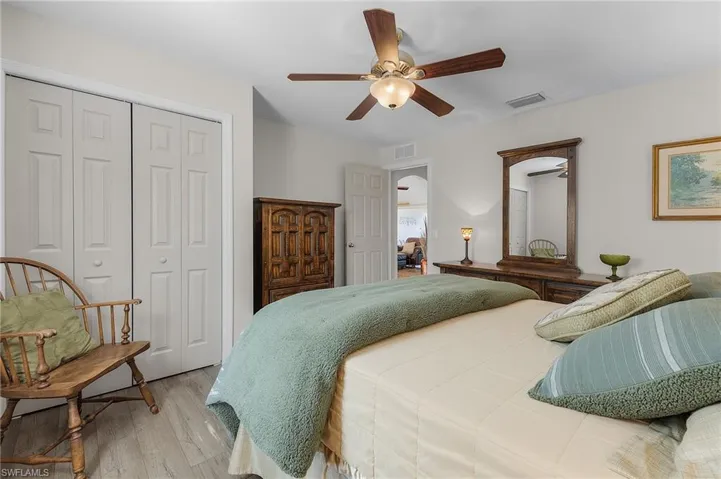 Bedroom with a closet, ceiling fan, and light hardwood / wood-style flooring