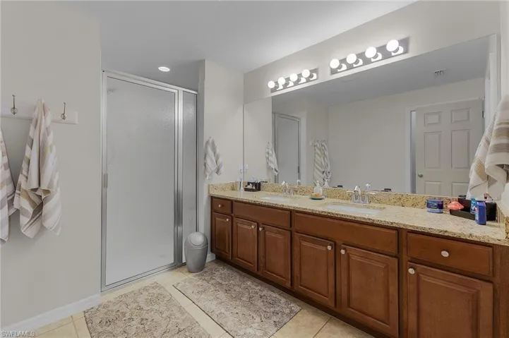 Bathroom featuring tile patterned floors, vanity, and an enclosed shower