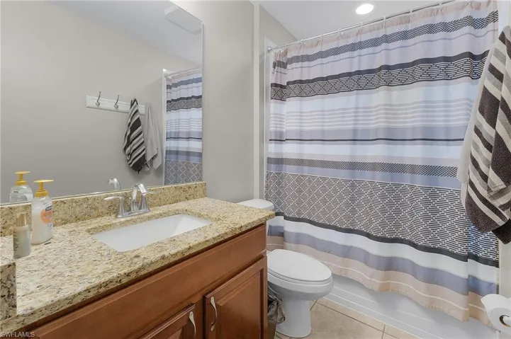 Full bathroom featuring tile patterned flooring, vanity, shower / tub combo with curtain, and toilet