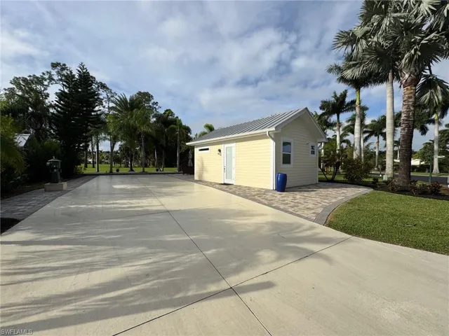 View of side of property with an outdoor structure and a garage