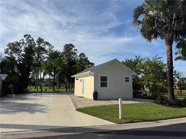 View of property exterior with a lawn and an outbuilding
