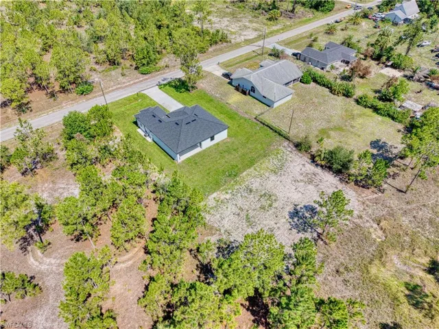 Newly constructed residence featuring a dark shingle roof and a concrete driveway