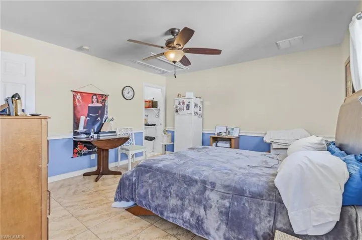 Bedroom featuring white fridge and ceiling fan