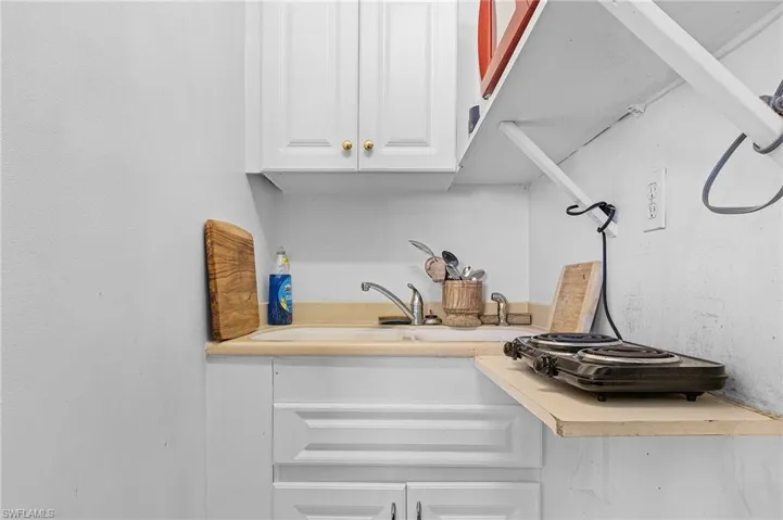 Kitchen featuring white cabinetry and sink