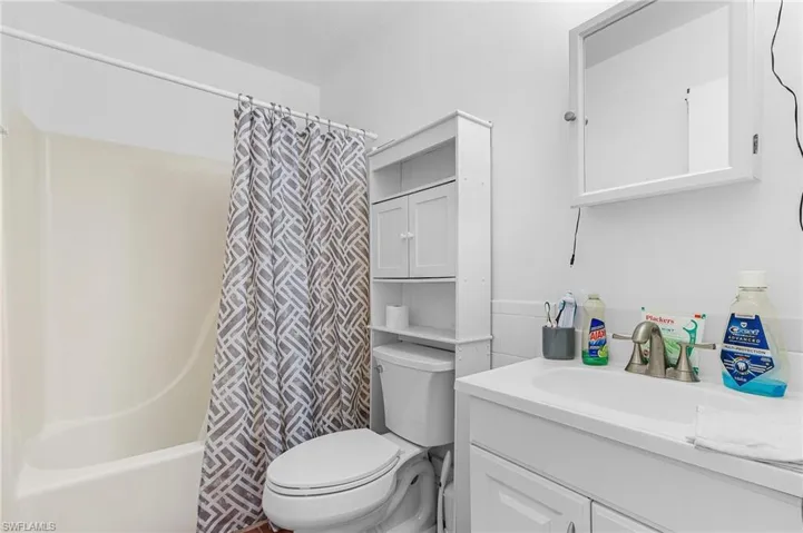 Full bathroom with shower / tub combo with curtain, vanity, and toilet