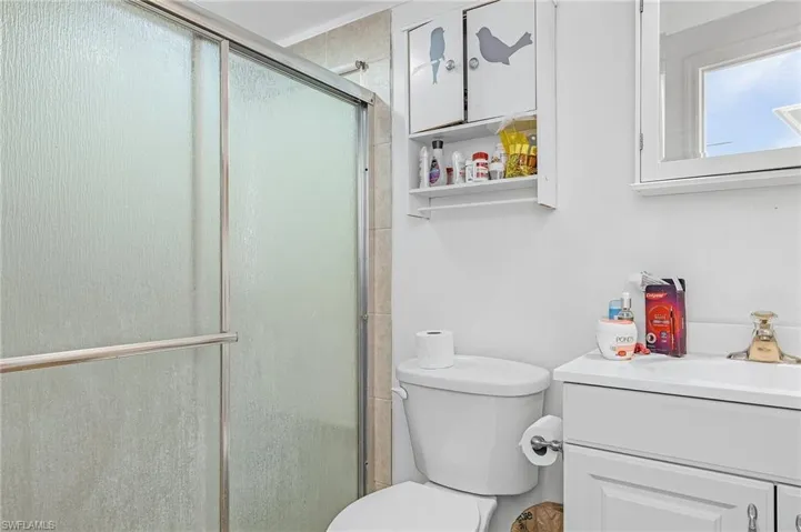 Bathroom with vanity, toilet, and a shower with door