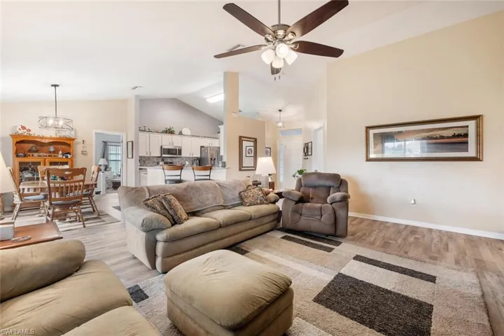 Living room featuring ceiling fan, high vaulted ceiling, and light hardwood / wood-style floors