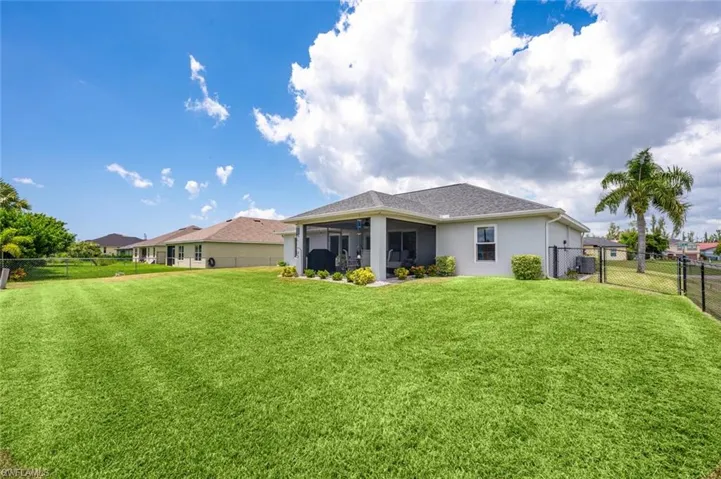 Back of property with a lawn