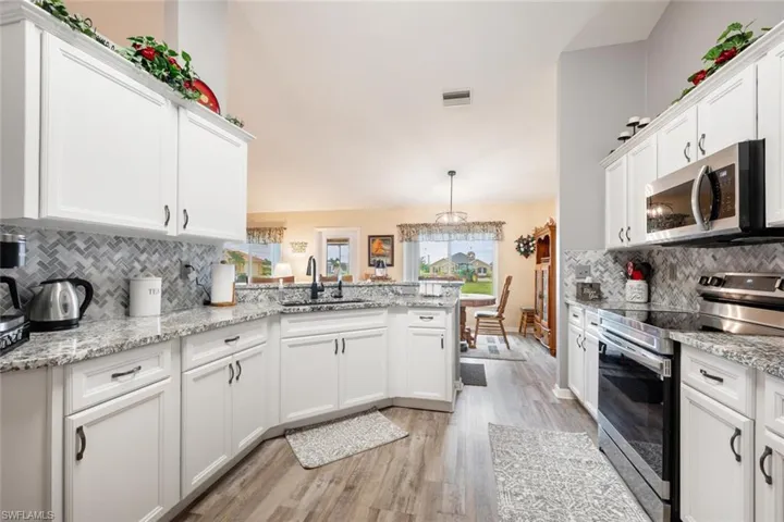 Kitchen featuring stainless steel appliances, backsplash, light hardwood / wood-style flooring, sink, and kitchen peninsula