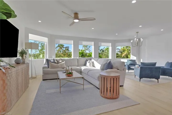 Living area featuring recessed lighting, light wood finished floors, ceiling fan, and a chandelier