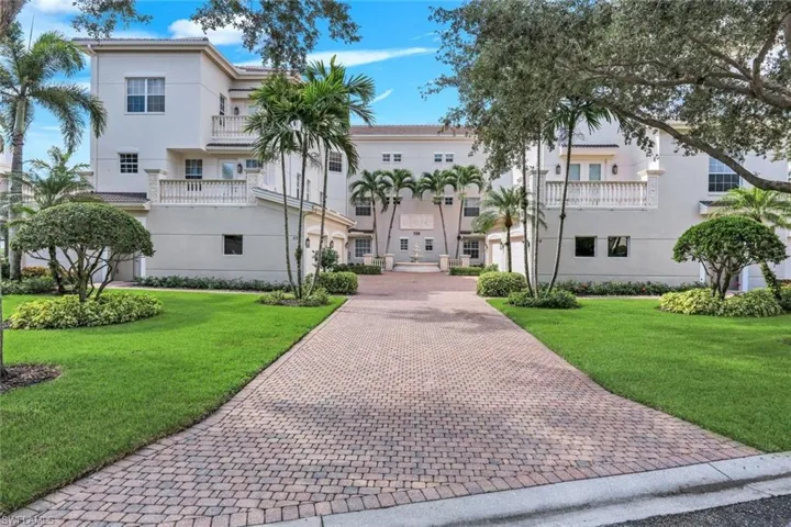 BUILDING 14 ADORNED BY PALMS AND OAK TREES WITH LUSH GREEN GRASS AND TROPICAL PLANTINGS